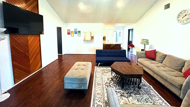 A spacious living room with a ceiling fan, a sofa, a coffee table, and a patterned rug. - Super Cozy 4 Bedroom by Premier Host - Sleeps 10 |  (Katy)