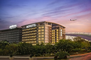 A hotel with a modern design, featuring multiple floors and a prominent signage. - Novotel Guangzhou Baiyun Airport (Guangzhou)