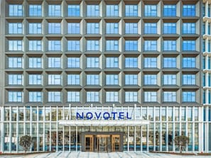A modern hotel with a grid of windows, a glass entrance, and the name 'NOVOTEL' displayed above the doors. - Novotel Guangzhou Baiyun Airport (Guangzhou)