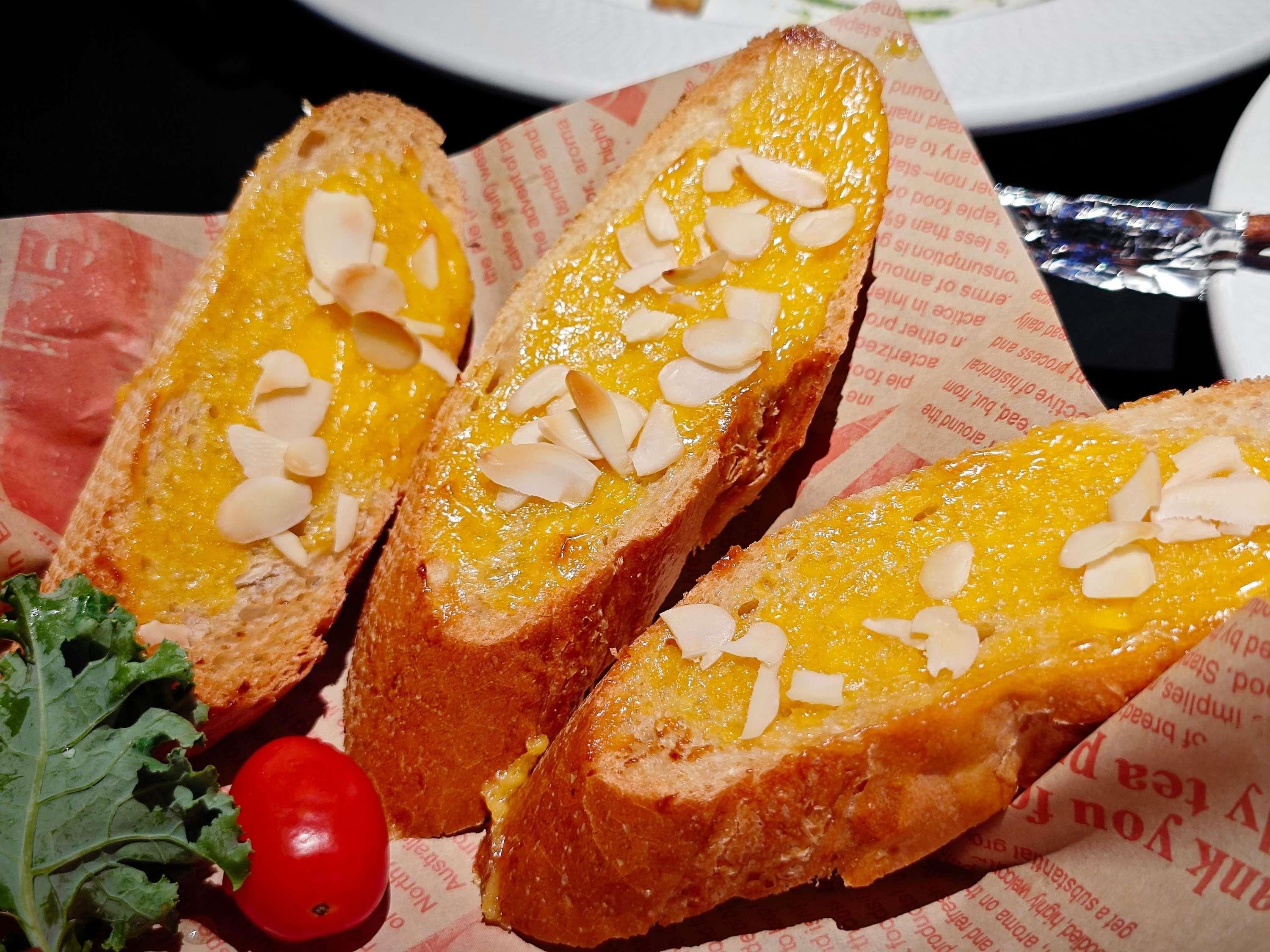 Ein Sandwich mit Belag, dazu ein Tomate und Salat.