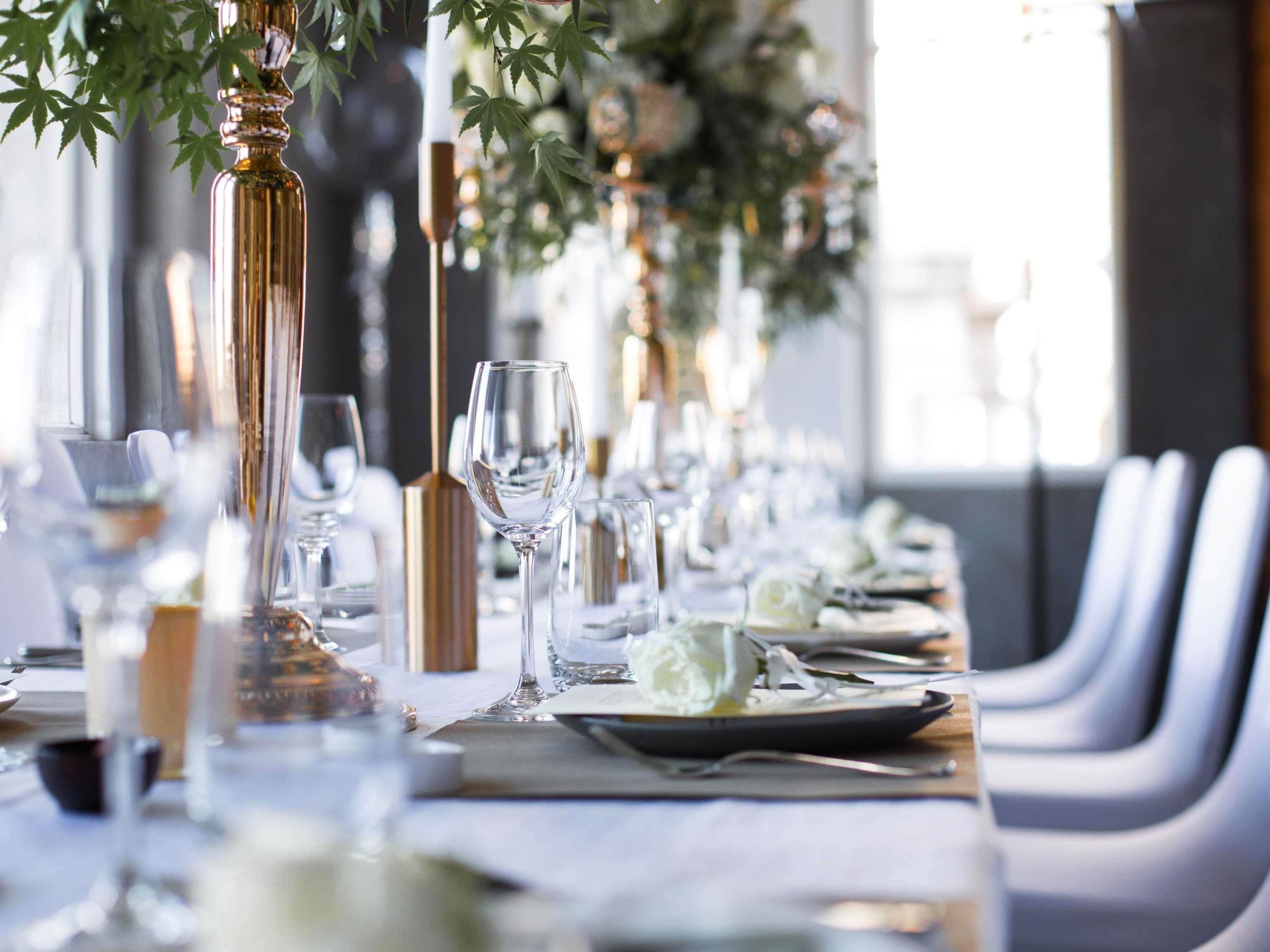 A long table set for a formal event with clear glassware and elegant table settings.