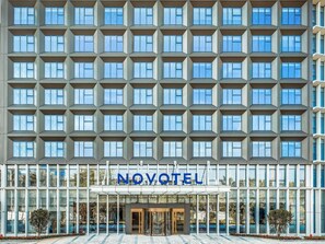 Moderni hotelli, jossa on suuri ikkunajulkisivu ja keskeinen sisäänkäynti lasiovella.
