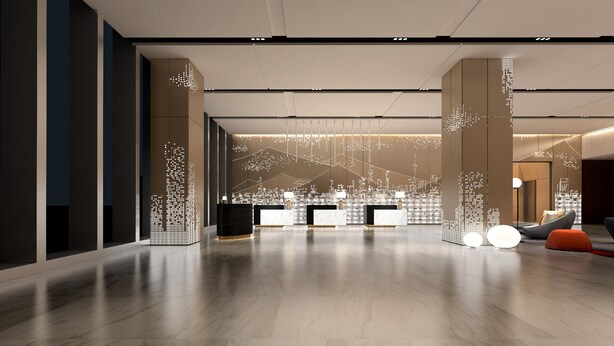 Een ruime lobby met een modern receptiebalie, een zithoek met oranje poefs en decoratieve verlichting aan de muren.