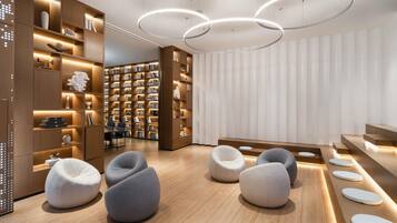 Interior moderno de una biblioteca con estanterías, asientos y una iluminación original.