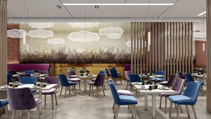 Een modern restaurant met een stadsgezichtsmural, blauwe en paarse stoelen en een houten vloer.