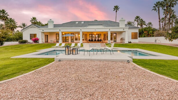 A large house with a swimming pool, outdoor seating, and a well-maintained lawn. - Sunridge by AvantStay | Glorious Estate w/ Pool, Hot Tub, Ping Pong & Pool Table (Scottsdale)