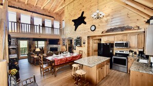 A spacious wooden cabin with a large dining area, kitchen, and a balcony. - Cozy Mountain Retreat, Open Concept, 7 Min To GSM Parkway, 5Br/5Ba, King Beds, (Sevierville)