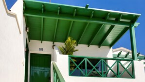 A white building with green accents, a staircase, and a door marked with the number 209. - Appartement Villalia  (Puerto del Carmen)