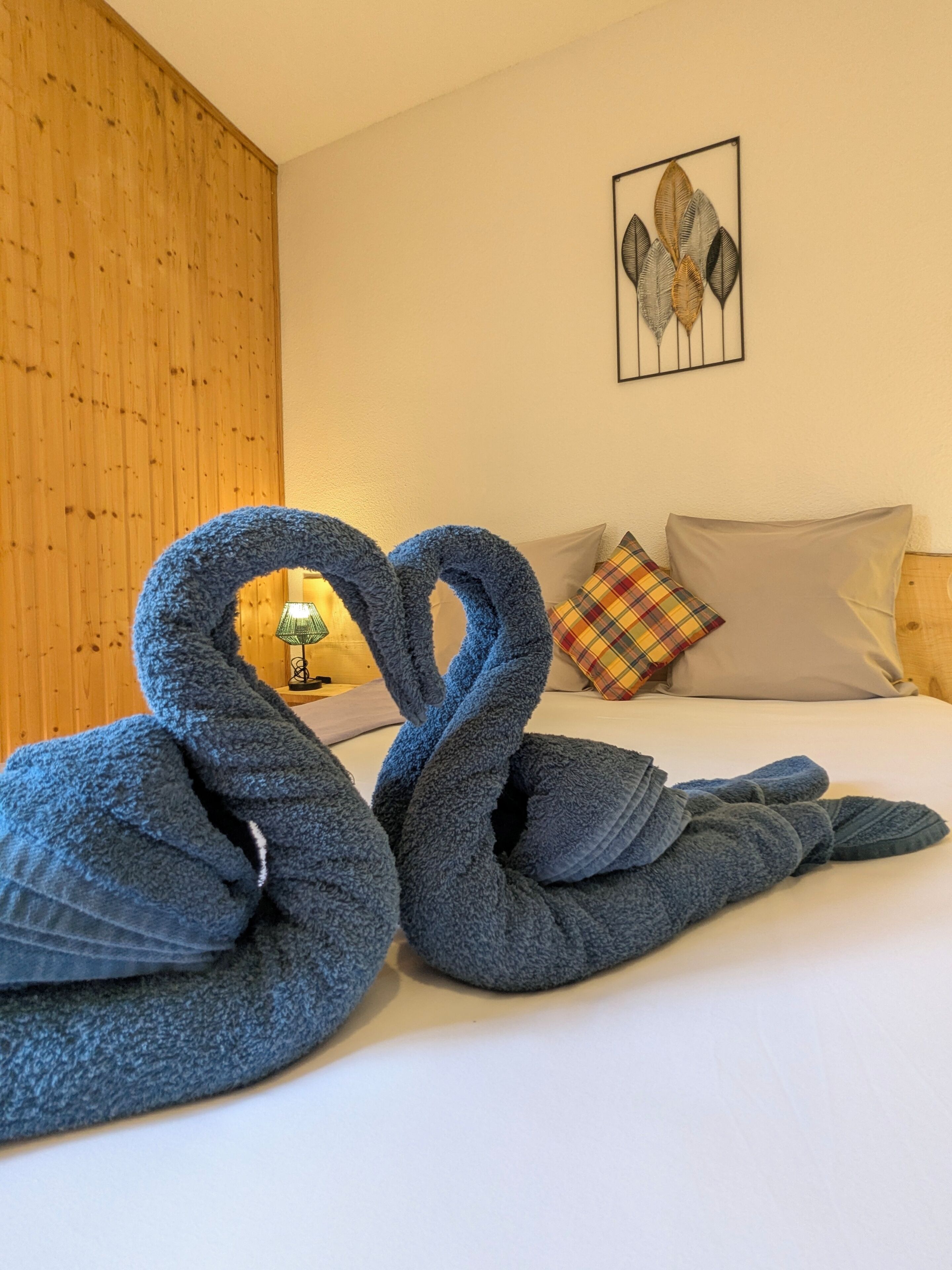 Een hotelkamer met een bed, een kunstwerk aan de muur en een lamp.