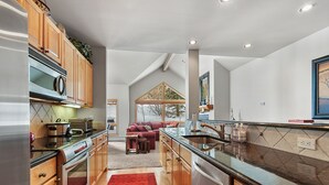 Una cocina moderna con armarios de madera, electrodomésticos de acero inoxidable y un tapete rojo.