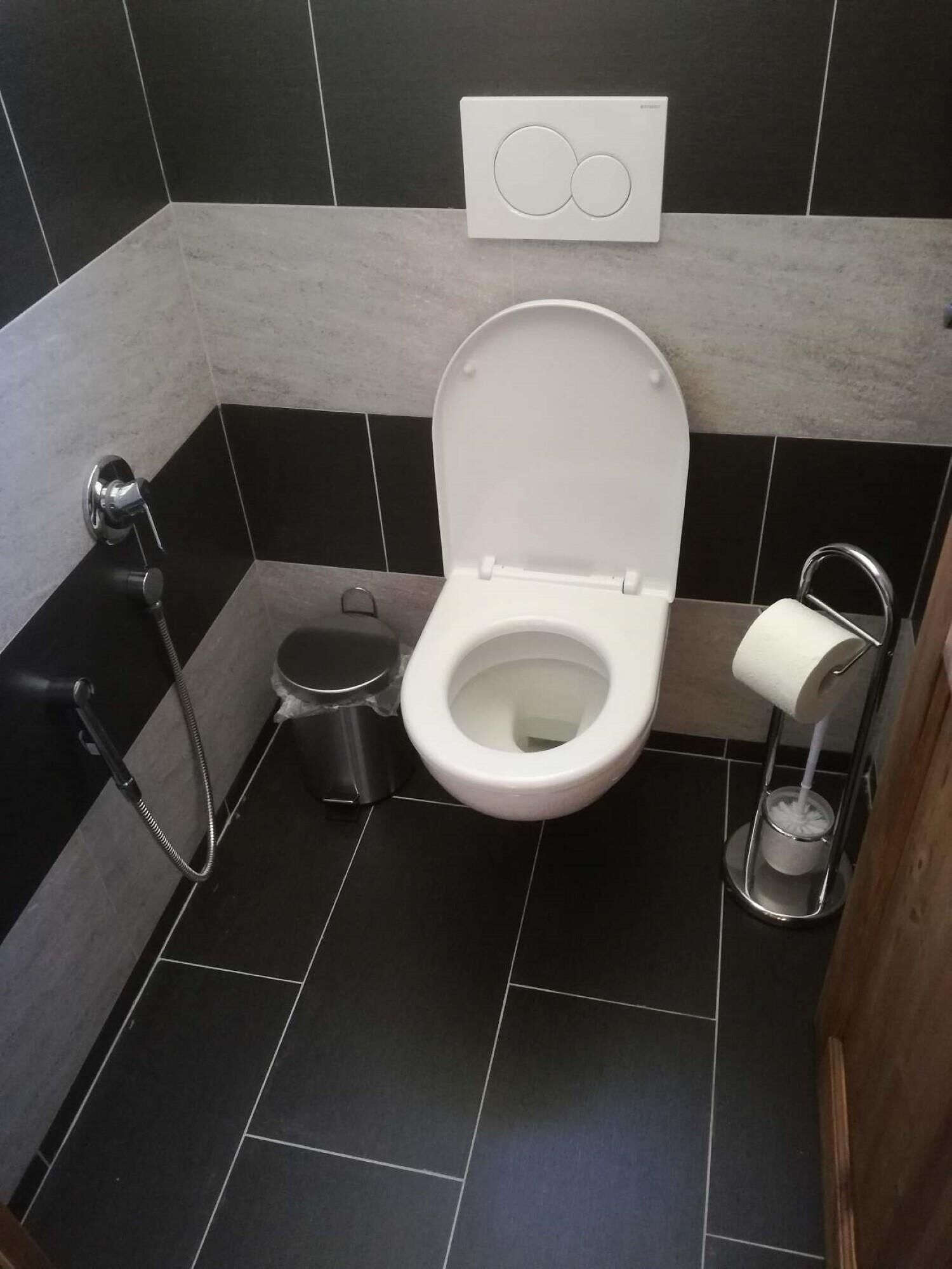 Un baño moderno con inodoro, bidé y secador de manos.