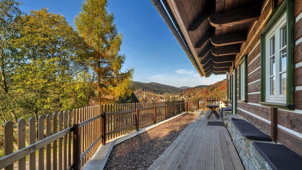 A wooden deck with a railing, a bench, and a building with windows. - Horni Marsov Khk320 in Horn Mar ov (Horni Marsov)