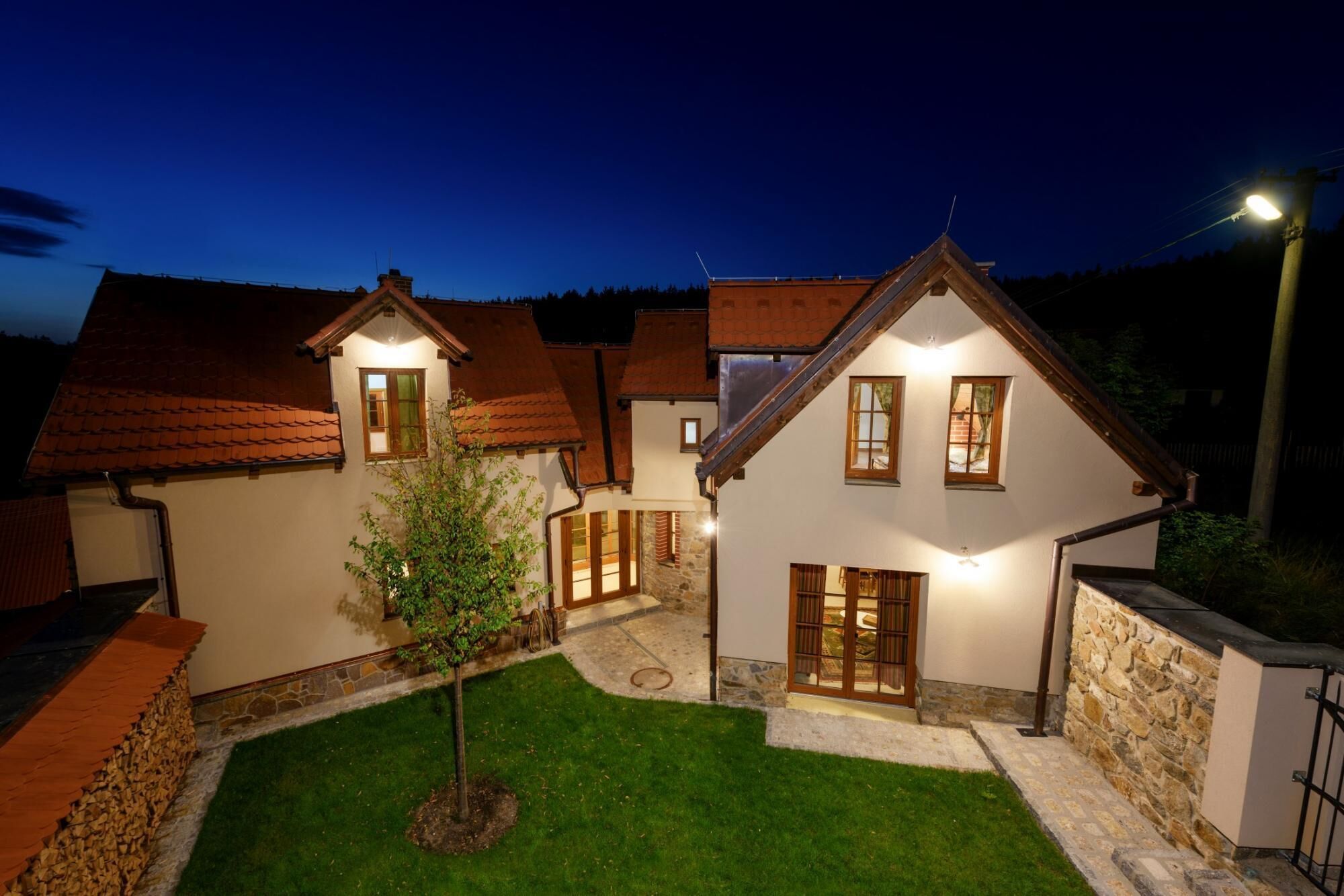 A traditional house with a stone foundation, wooden beams, and a tiled roof.