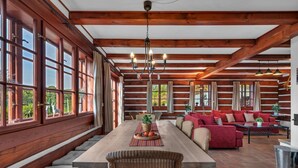 A log cabin interior with a dining area, sofa set, and large windows. - Villa Pool Stupna Ksf095 (Vidochov)
