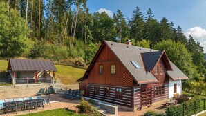 A cabin with a sloped roof, a covered patio with outdoor seating, and a fenced yard. - Villa Pool Stupna Ksf095 (Vidochov)