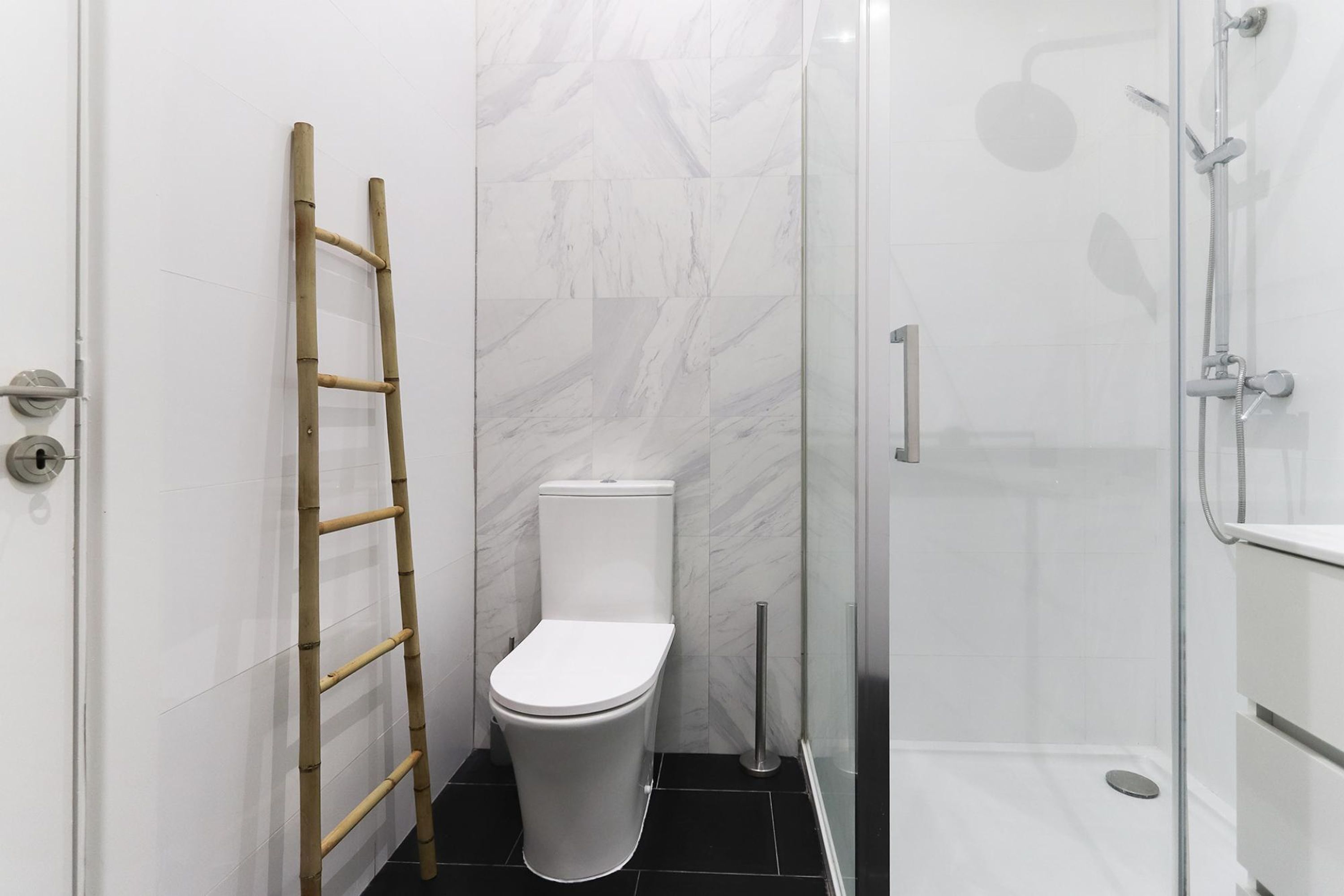 Un baño con inodoro, ducha y escalera.