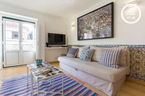 Relax in this stylish living room with a sofa, flat-screen TV, and city view.