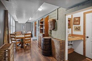 A rustic kitchen with wooden furniture, a barrel, and a sink.