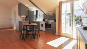 Una cocina moderna con comedor, electrodomésticos integrados y un amplio ventanal.
