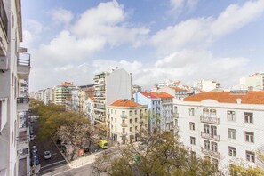 A city street with buildings, a yellow bus, and a clear sky. - Saldanha Concept by Homing (Lisbon)