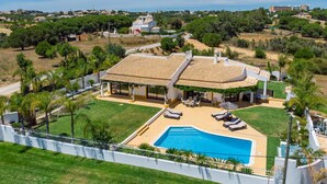 A large house with a swimming pool, covered patio, and a view of the surrounding landscape. - Casinha in Albufeira (Albufeira)