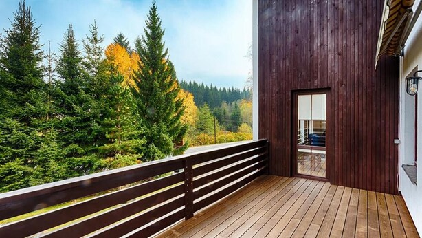 A wooden deck with a railing overlooking a forested area. - Harrachov Lhje260 in Harrachov (Harrachov)