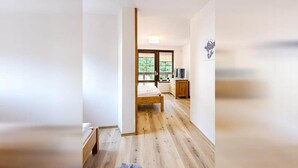 A room with a wooden floor, a bed, a dresser, and a television. - Harrachov Lhje260 in Harrachov (Harrachov)