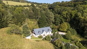 Une maison entourée d’une forêt dense, offrant une vue dégagée sur la propriété et son environnement naturel.