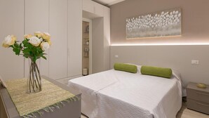Une chambre à coucher comprenant un lit, une table de chevet, une commode, un vase avec des fleurs et une œuvre d’art accrochée au mur.