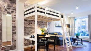 A room with a bunk bed, a dining table with chairs, a sofa, a ladder, and a view of the outside through a window. - Shabby Chic Apartment in ideal Location (Hamburg)