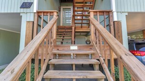 A wooden staircase leading to a door marked with the number 13, flanked by railings.