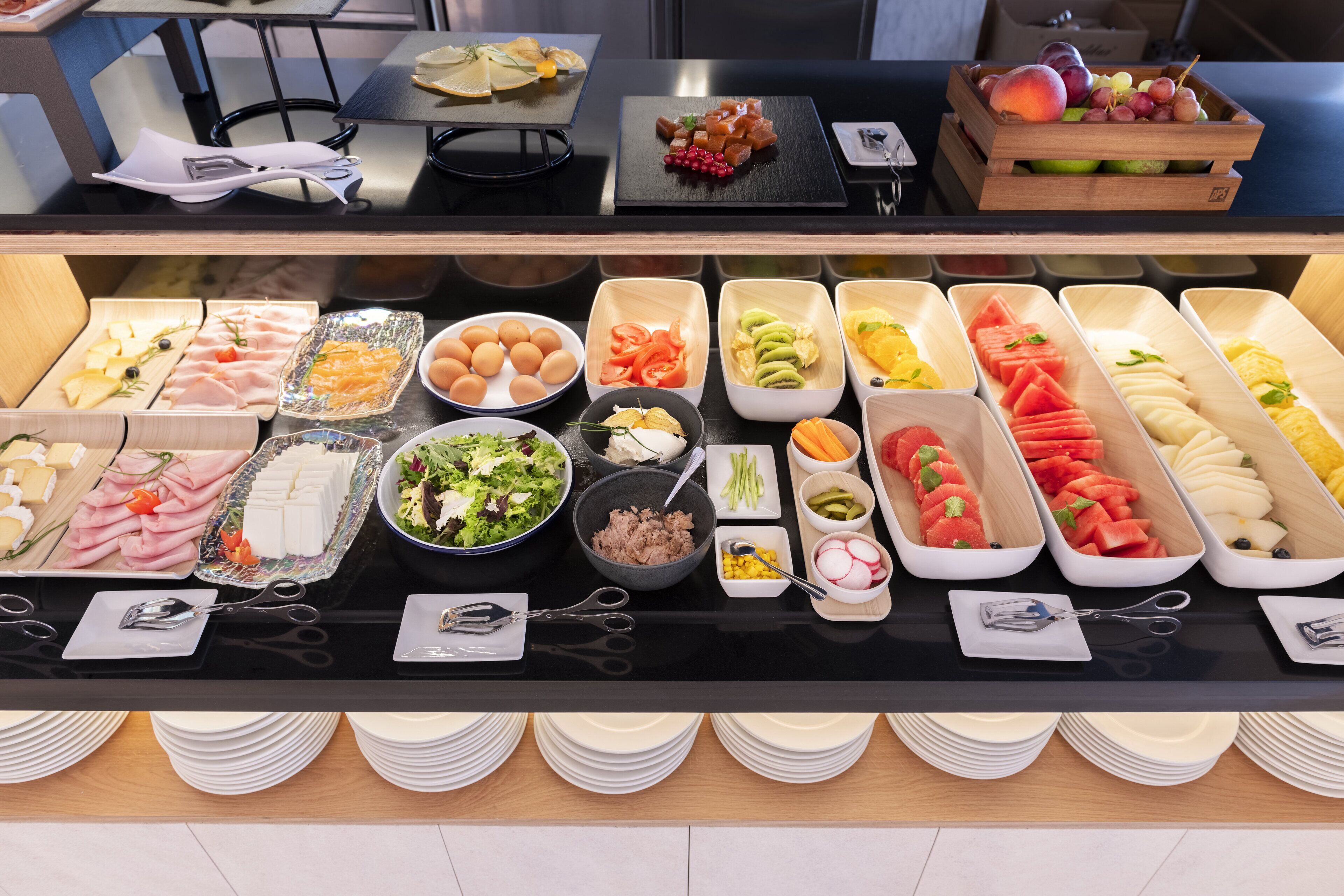 A buffet with various food items and utensils.