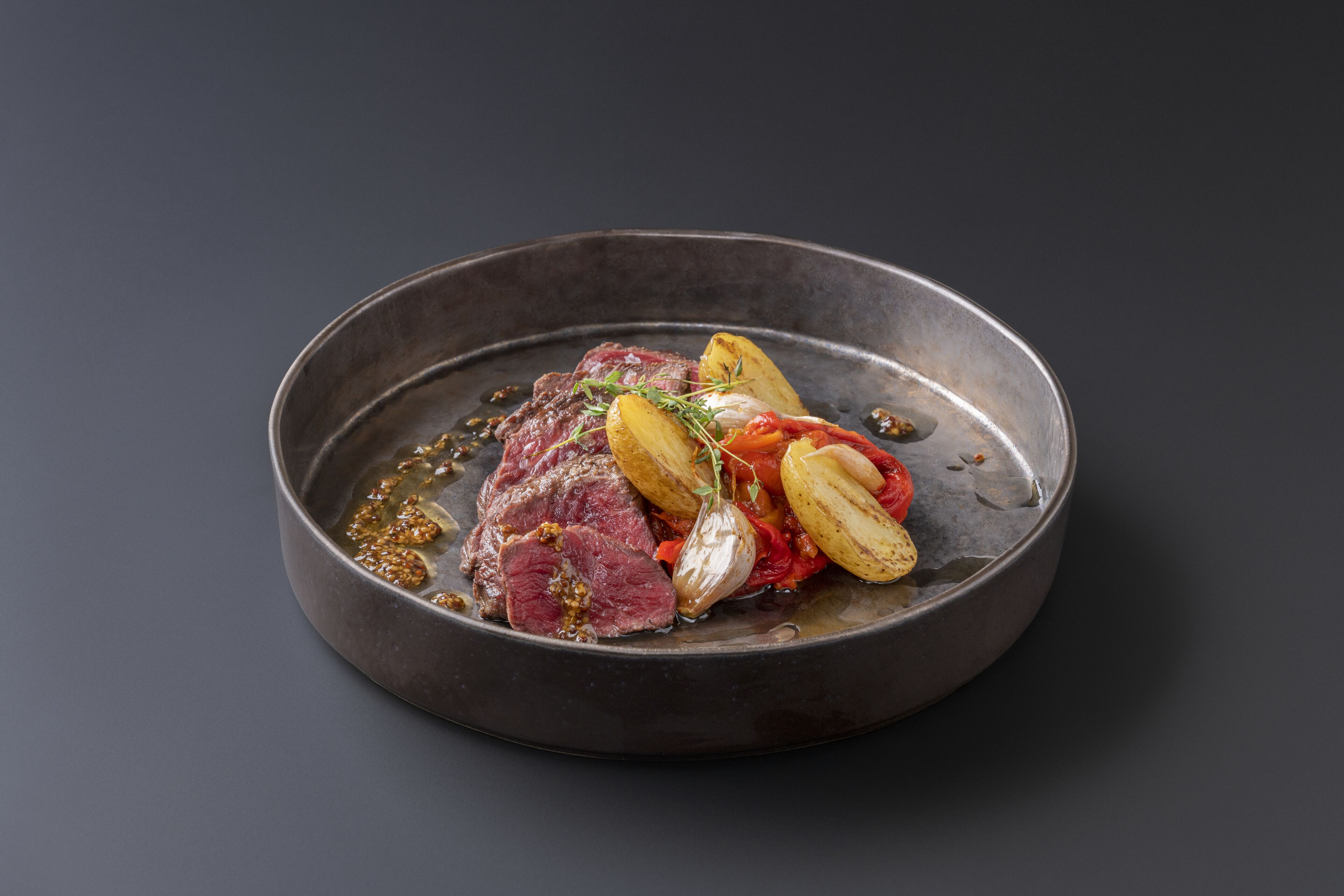 Plat amb sínia, patates i verdures en una paella.