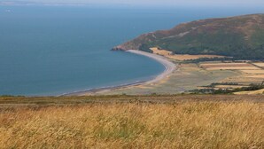 A coastal landscape with a beach, fields, and hills. - 1 Tregonwell Court (Minehead)