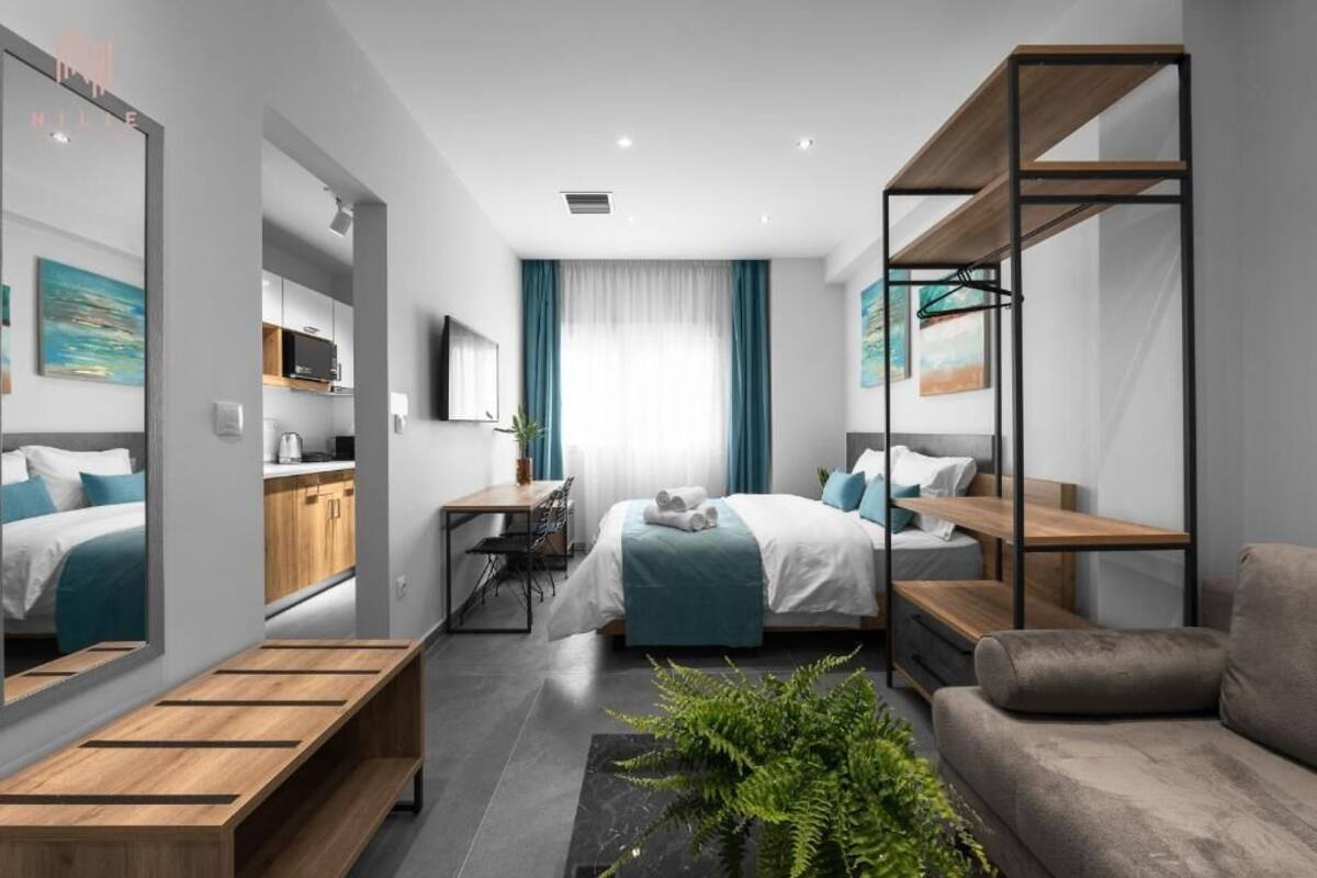 Une chambre d’hôtel moderne équipée d’un lit, d’un canapé, d’un bureau et d’un coin repas.