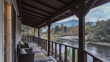 Un portico coperto con vista su un fiume e montagne.