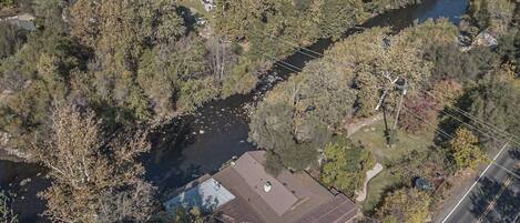An aerial view of a residential area with a river, houses, and a road.