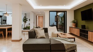 A modern living room with a sofa, a coffee table, and a TV mounted on the wall. - - 201 Provenza ⚡ Astonishing 3BR - A/C ⚡ Private Jacuzzi (Medellín)