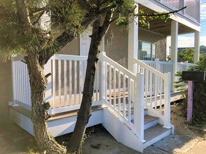 A house with a white porch and a staircase leading to the entrance. - 7 Bedroom, great for Groups close to Northside Park and Beach (Ocean City)
