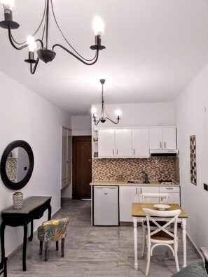 Suite junior | Cocina privada | Refrigerador, parrilla de estufa, utensilios de cocina y comedor