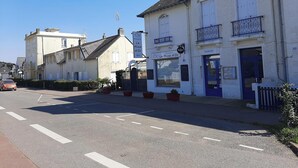 Un immeuble avec une enseigne indiquant « RÉSIDENCE DE L’OCÉAN » et une autre enseigne pour le « Bar La Mine d’Or ».