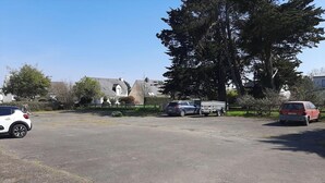 Un parking avec plusieurs voitures et une remorque.