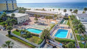 Ein Hotel mit mehreren Swimmingpools, Meerblick und einem Parkplatz.