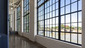 A spacious corridor with large windows and a view of a river. - The Warehouse Hotel at Champion Mill (Hamilton)