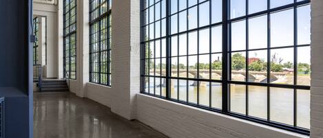 A spacious corridor with large windows and a view of a river.