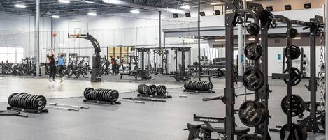 A gym with various weightlifting equipment, including barbells and weight plates.