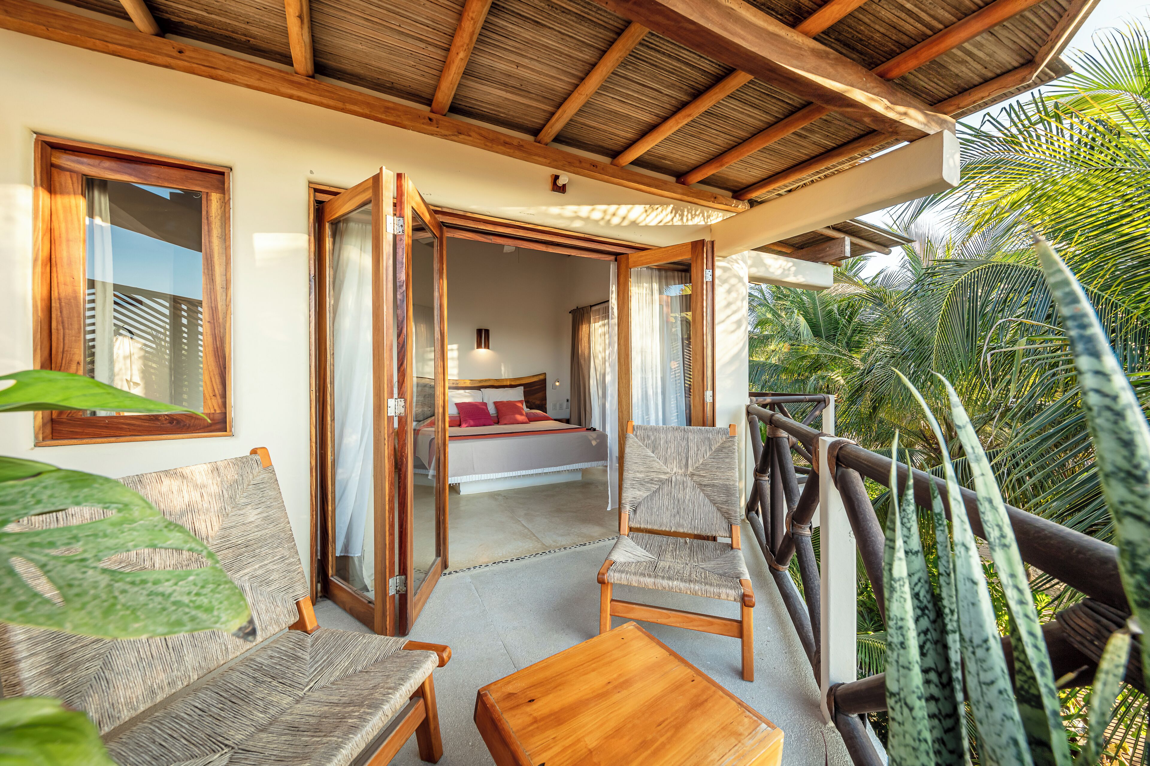 A room with a bed, a wooden table, and a chair.