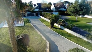 Una strada residenziale con case, un manto stradale asfaltato e prati curati.