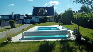 Una casa moderna con piscina, prato curato e ampio giardino.