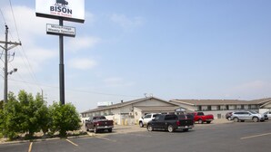 A BISON Inn & Suites with a parking lot and several vehicles. - Bison Inn and Suites (Fargo)
